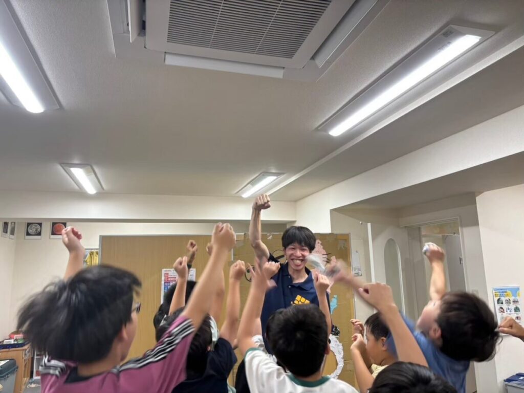 教室で講師と子どもたちが元気に手を挙げて盛り上がっている様子