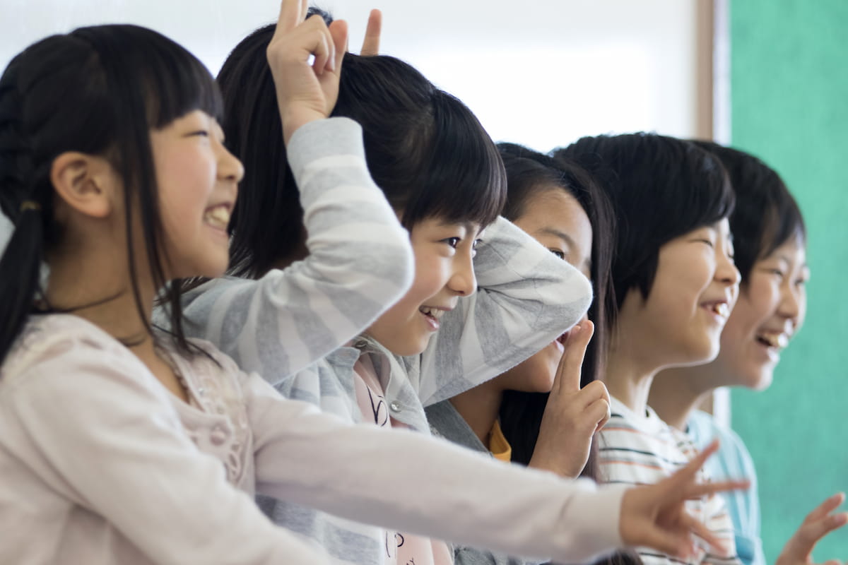 小学生が友達と教室で遊ぶ