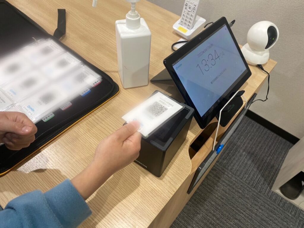 入退館端末にカードをかざす子ども