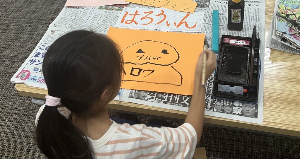 習字でハロウィンのかぼちゃを書く様子